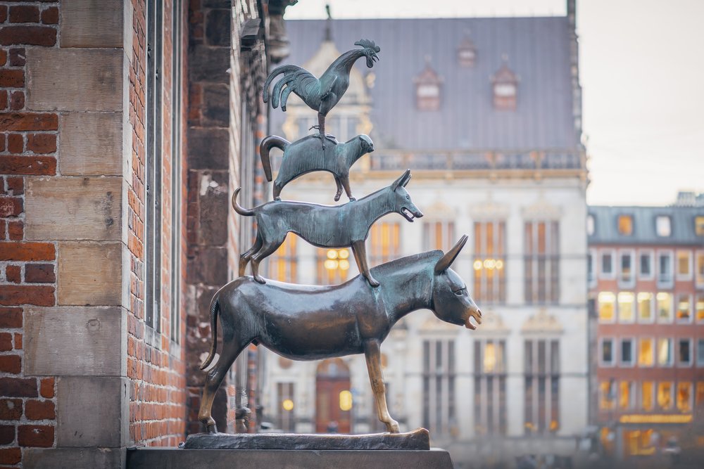 Statue der Bremer Stadtmusikanten. Auf dem Esel stehen Hund, Katze und ganz oben der Hahn. Schnauze und Vorderbeine des Esels sind goldfarben vom häufigen Anfassen durch Besucher, was wiederum Glück bringen soll